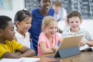 Stock photo of happy children with device