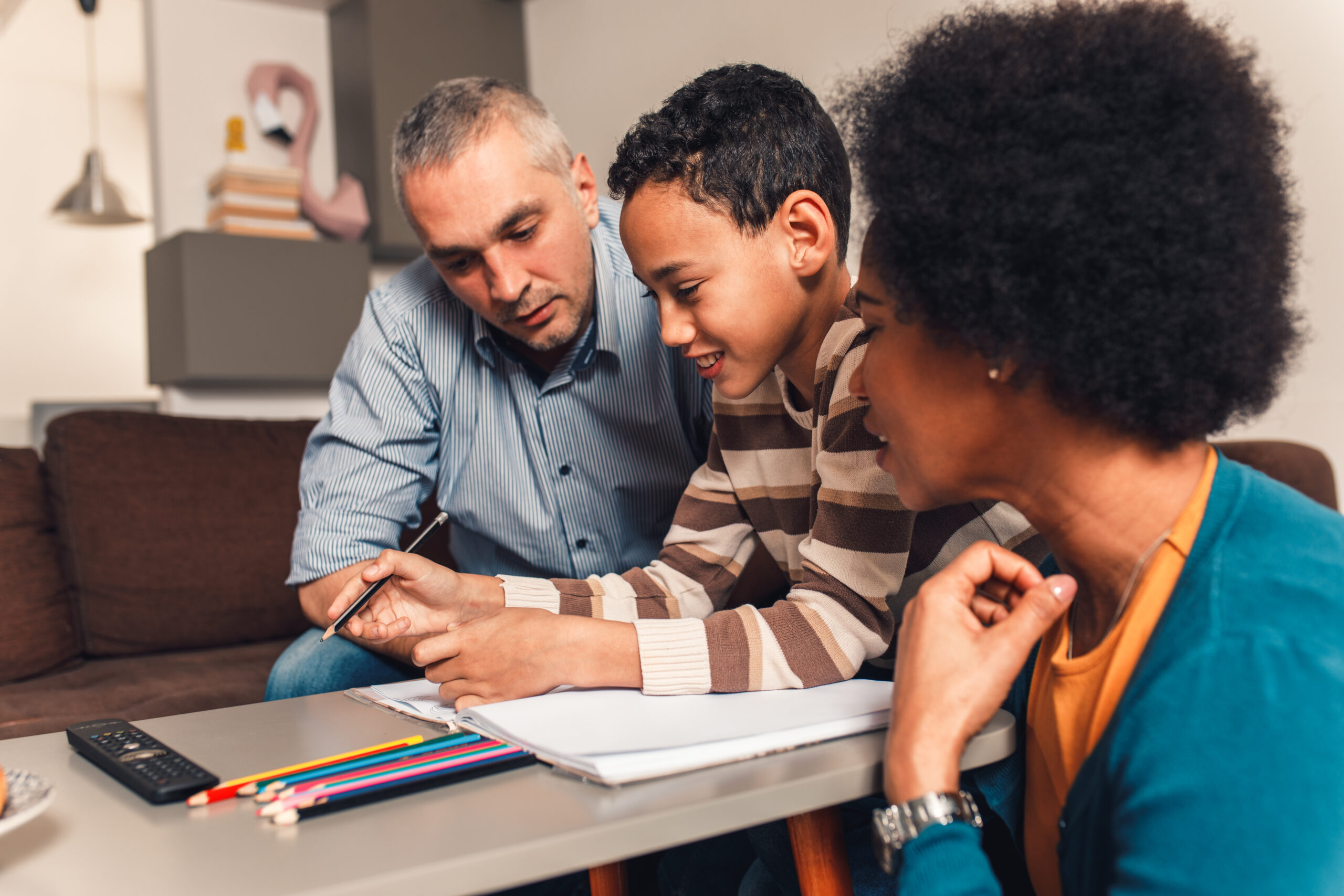 Two parents helping their child with schoolwork