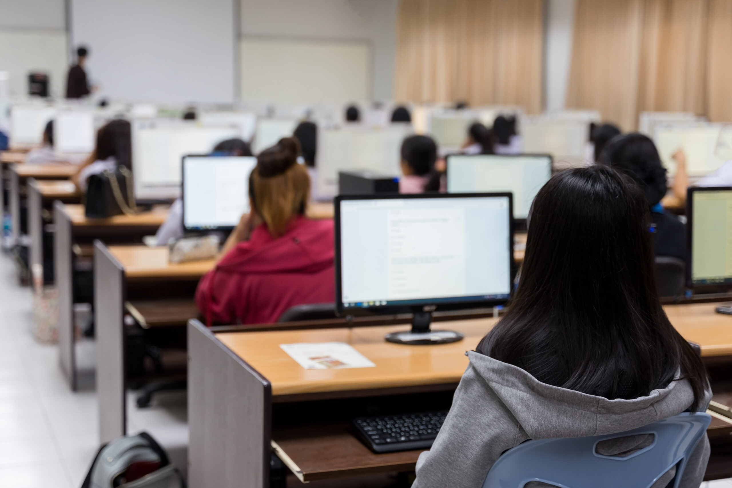 university student using computer studying in computer room. Group of students in study in computers room. Serious students working on computer at university.